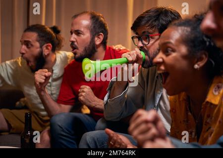 Nahaufnahme der besten Freunde, die zu Hause Sportwettkämpfe im fernsehen sehen und ein gutes Spiel genießen. Stockfoto
