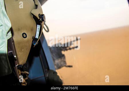 Ein Besatzungsmitglied mit 3. Angriffs-Helikopter-Bataillon, 142. Aviation Regiment, Teil der Task Force Spartan, sieht zu, wie ein Schütze während einer Flugausbildung Ziele aus dem UH-60 Blackhawk anvisiert. Durch diese Schulung wird sichergestellt, dass das gesamte Personal mit den Waffensystemen vertraut ist und sie beherrscht und Einsatzbereitschaft schafft. (USA Armeefoto von Sergeant Gabriel Washington) Stockfoto