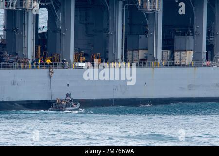 NATUNA SEA (7. Januar 2023) – Marines, die einem Marine-RAID-Force-Zug (MRF) zugeteilt sind, besteigen an Bord eines Amphibien-Transportschiffs USS Anchorage (LPD 23) an Bord von Lewis B. Puller-Class Expeditions-Basis USS Miguel Keith (ESB 5) über ein 11m starres Rumpf-Schlauchboot (RHIB) während eines Besuchs, Besuch, Board, Suche Und Anfallsübung (VBSS), Januar 7. Durch die Synchronisierung der komplementären Fähigkeiten der 13. Marineexpeditionstruppe (MEU) und der USS Anchorage wird der traditionelle Einfluss der Meeresenergie verstärkt, um eine wettbewerbsfähigere und tödlichere Kraft zu erzeugen. Die Makin Island Amphibious Ready Group, Comp Stockfoto