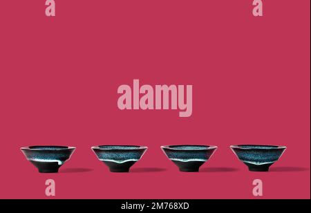 Dunkelblaue Tonbecher, gefüttert mit trendy magentafarbener Farbe des Hintergrunds aus dem Jahr 2023. Kreatives minimalistisches Teezeremoniekonzept. Speicherplatz kopieren. Stockfoto