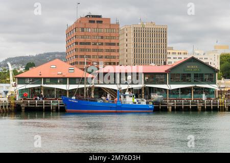 HOBART, TASMANIEN, AUSTRALIEN. 06. März 2022. Das Fischerboot liegt im Victoria Dock neben dem Meeresfrüchtegerestaurant Mures. Stockfoto