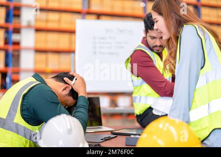 Eine Gruppe von Mitarbeitern in der Lagerfabrik führt am Morgen vor Arbeitsbeginn ein Toolbox-Gespräch durch und führt ein Brainstorming durch Stockfoto