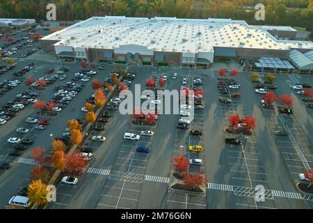 Luftaufnahme des großen Parkplatzes vor dem Getränkegeschäft mit vielen parkenden bunten Autos. Parkplatz am Supercenter Einkaufszentrum mit Warteschlangen und Stockfoto