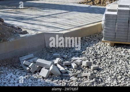 Vorbereitung für das Verlegen von Graubetonsteinen sowie von Straßenbauarbeiten zur Landschaftsgestaltung von zu verlegenden Deckenfertigern Stockfoto