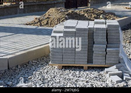 Vorbereitung zum Verlegen von grauen Betonsteinen ein Gehweg Bauarbeiten Landschaftsbaufertiger Stockfoto