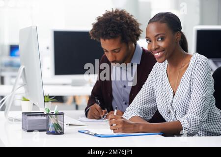 Sie arbeitet gern mit ihm zusammen. Zwei Kollegen, die in einem Büro sitzen. Stockfoto