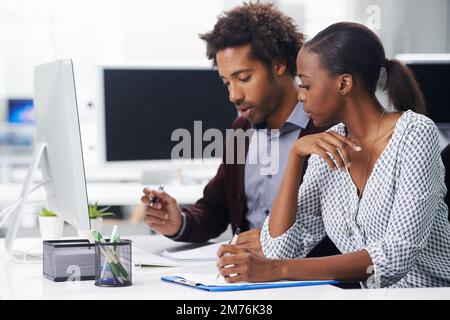 Kommen wir zur Sache. Zwei Kollegen, die in einem Büro sitzen. Stockfoto