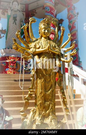 Golden Thousand-Hand Guan Yin steht vor der großen Guan Yin-Statue im chinesischen Pavillon. Stockfoto