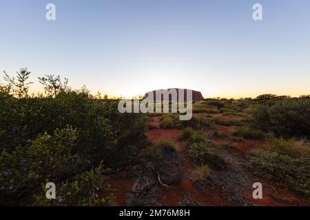 Outback, Australien - 12. November 2022: Sonnenaufgang am Majestic Uluru oder Ayers Rock im Northern Territory, Australien. Der rote Stein im Zentrum Stockfoto