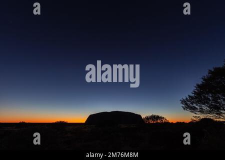 Outback, Australien - 12. November 2022: Sonnenaufgang am Majestic Uluru oder Ayers Rock im Northern Territory, Australien. Der rote Stein in der Mitte o Stockfoto