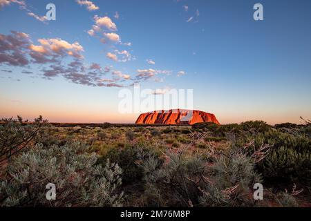 Outback, Australien - 12. November 2022: Sonnenaufgang am Majestic Uluru oder Ayers Rock im Northern Territory, Australien. Der rote Stein im Zentrum Stockfoto