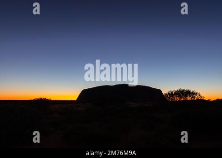 Outback, Australien - 12. November 2022: Sonnenaufgang am Majestic Uluru oder Ayers Rock im Northern Territory, Australien. Der rote Stein in der Mitte o Stockfoto