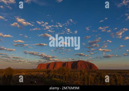 Outback, Australien - 12. November 2022: Sonnenaufgang am Majestic Uluru oder Ayers Rock im Northern Territory, Australien. Der rote Stein im Zentrum Stockfoto