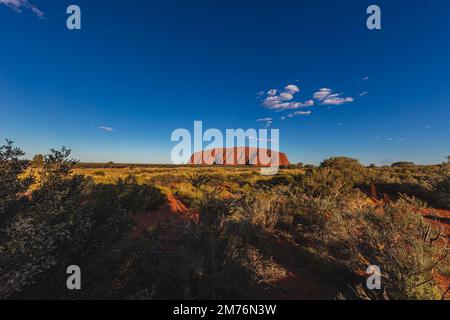 Outback, Australien - 12. November 2022: Sonnenaufgang am Majestic Uluru oder Ayers Rock im Northern Territory, Australien. Der rote Stein im Zentrum Stockfoto