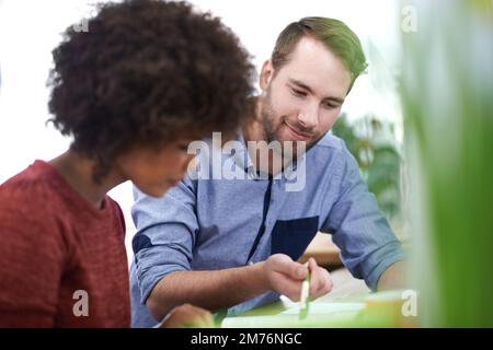 Ein Gedankenaustausch. Zwei junge Designprofis arbeiten in einer Büroumgebung zusammen. Stockfoto