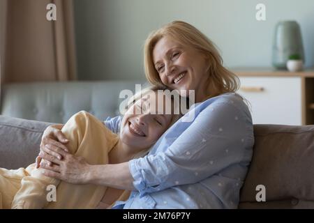 Glückliche reife mutter, die fröhliche Erwachsene Tochter mit Liebe umarmt Stockfoto