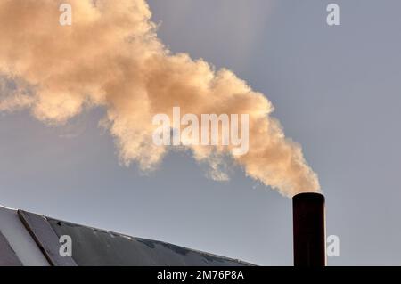 Rauch kommt aus dem Schornstein der Bourgeoisie, der Ofen wird erhitzt. Stockfoto