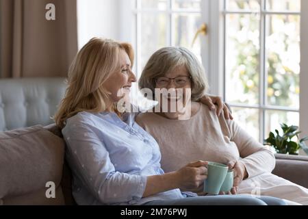Fröhliche, glückliche, ältere mutter und Erwachsene, reife Tochter, die Tee trinkt Stockfoto