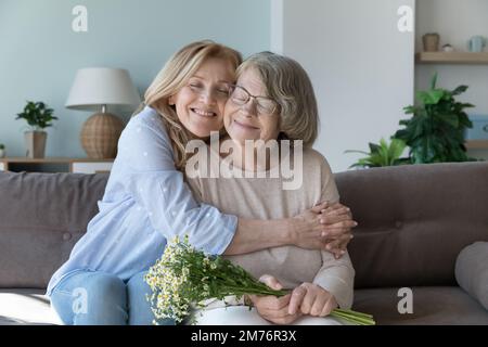 Glückliche, friedlich fürsorgliche Seniortochter, die ältere mutter umarmt Stockfoto