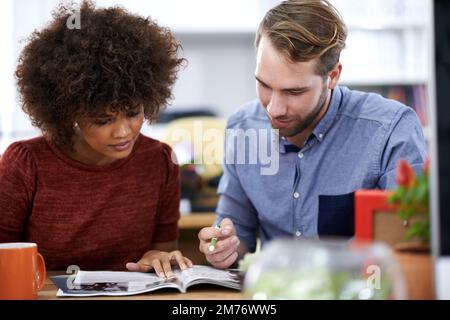 Begegnung der kreativen Köpfe. Zwei junge Designprofis arbeiten in einer Büroumgebung zusammen. Stockfoto