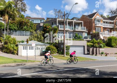 Zwei Damen fahren mit dem Fahrrad auf der Pittwater Road in Bayview, Sydney, NSW, Australien, um am Sonntagmorgen Radsport zu machen Stockfoto