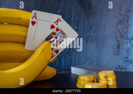 Bananenhand und Pokercard Stockfoto