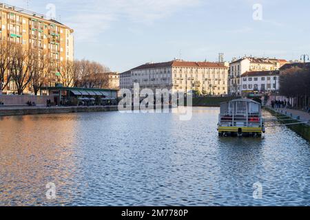 Mailand, Italien-Januar 05,2023: Menschen spazieren entlang des Ufers des Mailänder Naviglio-Kanals und entspannen sich in den Pubs, Mailand, Italien. Stockfoto