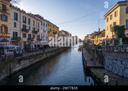 Mailand, Italien-Januar 05,2023: Menschen spazieren entlang des Ufers des Mailänder Naviglio-Kanals und entspannen sich in den Pubs, Mailand, Italien. Stockfoto