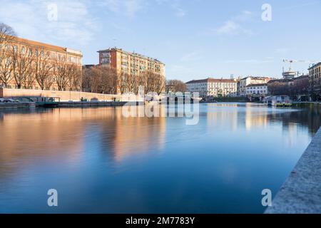 Mailand, Italien-Januar 05,2023: Menschen spazieren entlang des Ufers des Mailänder Naviglio-Kanals und entspannen sich in den Pubs, Mailand, Italien. Stockfoto