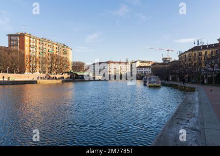 Mailand, Italien-Januar 05,2023: Menschen spazieren entlang des Ufers des Mailänder Naviglio-Kanals und entspannen sich in den Pubs, Mailand, Italien. Stockfoto