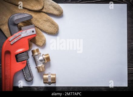 Affenschlüssel Rohrverbinder Messing Leder Sicherheitshandschuhe sauberes Papier. Stockfoto