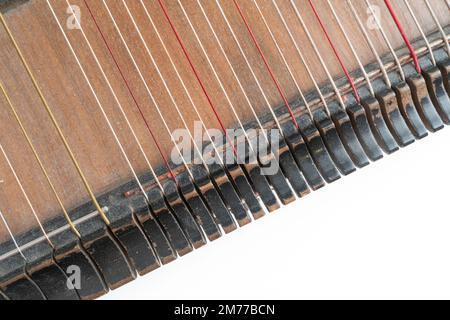 Top-horizontales Studiofoto eines alten Holzzithers isoliert auf weißem Hintergrund. Details von Zither-Zeichenfolgen erzeugen ein abstraktes Muster. Stockfoto