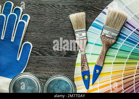Schutzhandschuhe Farbbürsten Dose pantone Fan auf Holzbrett. Stockfoto