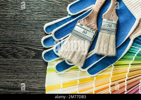 Schutzhandschuhe Farbbürsten pantone Fan auf Holzbrett. Stockfoto