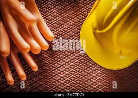 Isolierende Schutzhandschuhe Bauhelm auf dielektrischer Gummimatte. Stockfoto