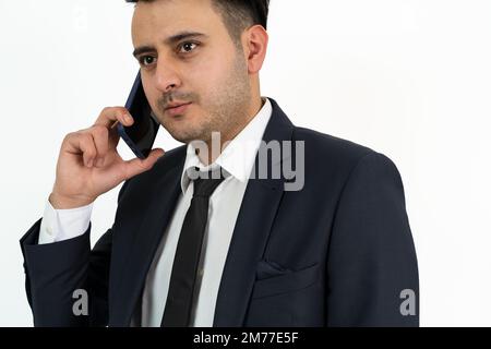 Nahaufnahme eines braungehäuteten Geschäftsmanns, der auf isoliertem Hintergrund mit dem Smartphone spricht oder spricht. Konzept für einen geschäftigen Arbeitsplatz. Stockfoto