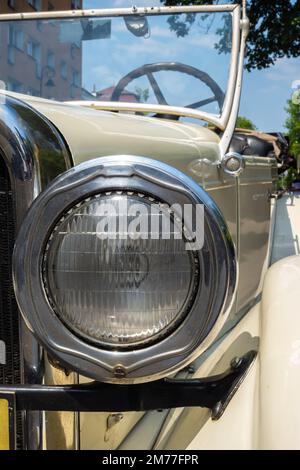 Runde Stirnlampe eines Oldtimer-Autos. Fahrzeuge aus der Zeit vor dem Zweiten Weltkrieg Stockfoto
