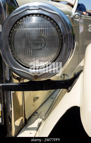 Runde Stirnlampe eines Oldtimer-Autos. Fahrzeuge aus der Zeit vor dem Zweiten Weltkrieg Stockfoto