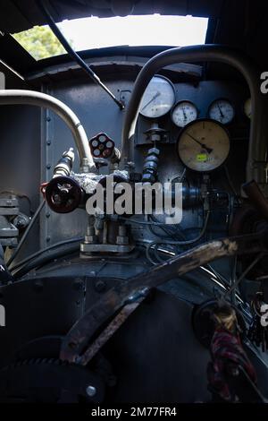 Ein Satz von Manometern und anderen Manometern an einem Dampflokomotivkessel. Das Innere eines Dampflokomotivenkiosks. Stockfoto