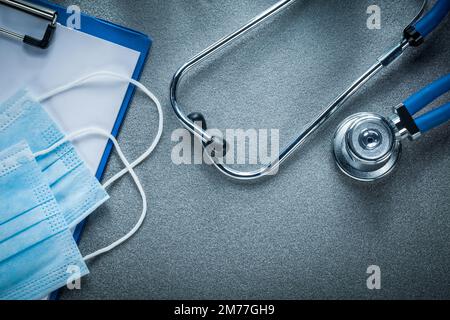 Stethoskop Clipboard sterile Einweg-medizinische Maske auf grauem Hintergrund. Stockfoto