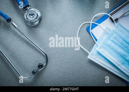 Stethoskop Clip Board Einweg-Gesichtsmaske auf grauem Hintergrund. Stockfoto