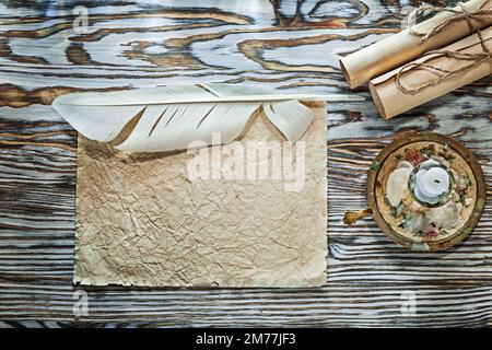 Klassische Papierrollen, zerknitterte Dokumente, Kerzenhalter, Kerze. Stockfoto