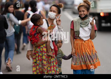 Zwei philippinische Mädchen mit kleinen Kindern aus der nahe gelegenen Badjao-Gemeinde posieren für ein Foto, während sie auf der Straße in Cebu City, Philippinen spazieren. Stockfoto