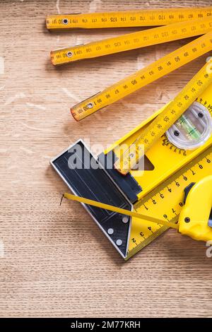 Hölzerne Messbandwaage und quadratisches Lineal auf Eichenholzplatte Stockfoto