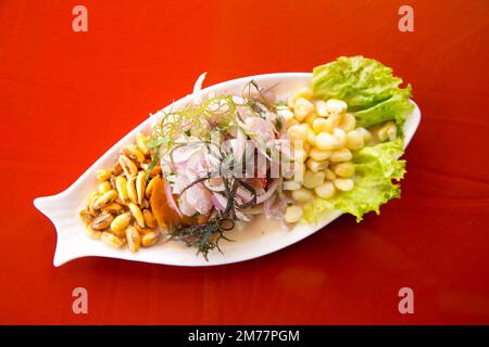 Zubereitung einer köstlichen peruanischen Seebarsch-Ceviche im Fischereihafen von Chorríos in Lima. Stockfoto