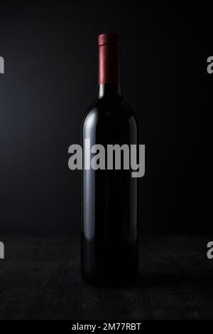 Flasche Rotwein auf dunklem Hintergrund. Stockfoto