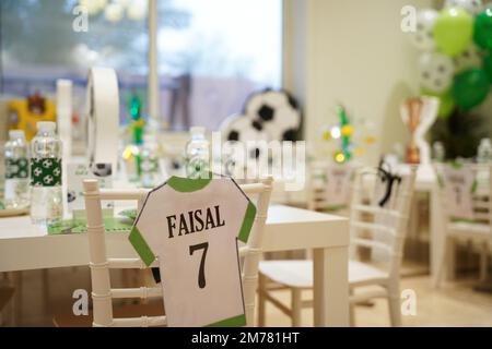 Kinderfußball- oder Fußball-Partytisch mit Plastikbesteck und Süßigkeiten. Festliche Dekoration zum Geburtstag, Boy Party. Geburtstagsgrüße. Stockfoto