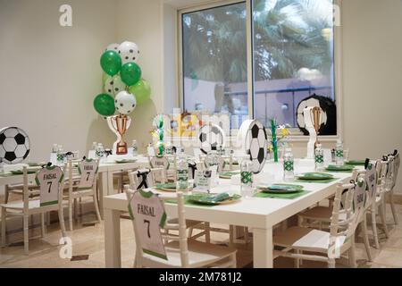 Kinderfußball- oder Fußball-Partytisch mit Plastikbesteck und Süßigkeiten. Festliche Dekoration zum Geburtstag, Boy Party. Geburtstagsgrüße. Stockfoto