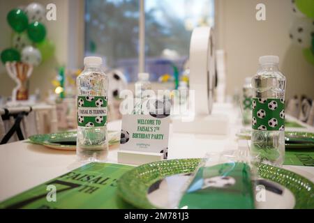 Kinderfußball- oder Fußball-Partytisch mit Plastikbesteck und Süßigkeiten. Festliche Dekoration zum Geburtstag, Boy Party. Geburtstagsgrüße. Stockfoto