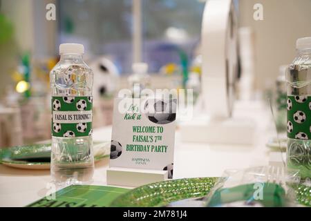 Kinderfußball- oder Fußball-Partytisch mit Plastikbesteck und Süßigkeiten. Festliche Dekoration zum Geburtstag, Boy Party. Geburtstagsgrüße. Stockfoto